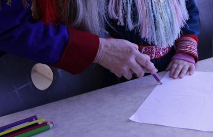 Barn og voksen tegner sammen i den samiske basen i Gimle studentbarnehage