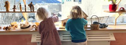 To barn som leker ved et vindu